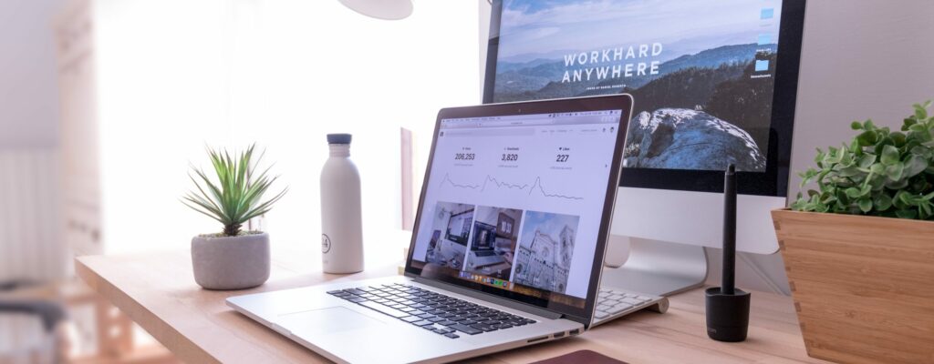 MacBook Pro on table beside white iMac and Magic Mouse